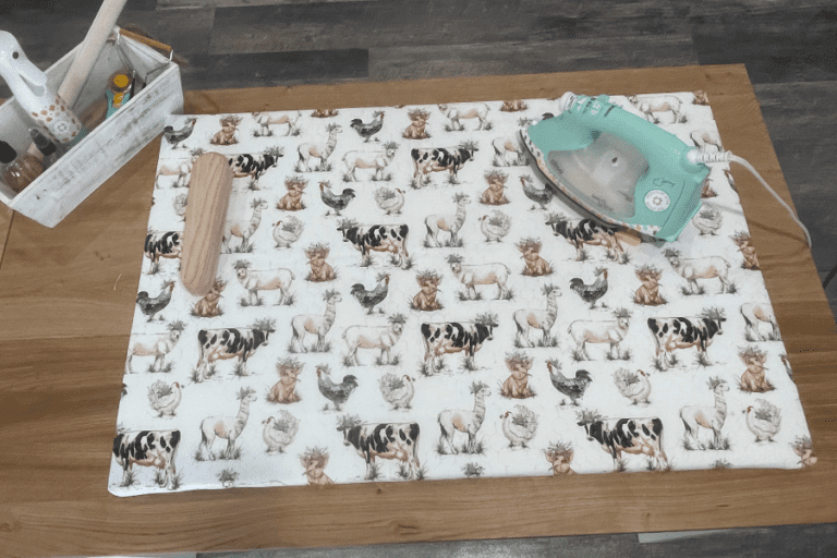 DIY Ironing Board made with MDF, Canvas, Batting. Shown flat lay with an iron and a pressing block