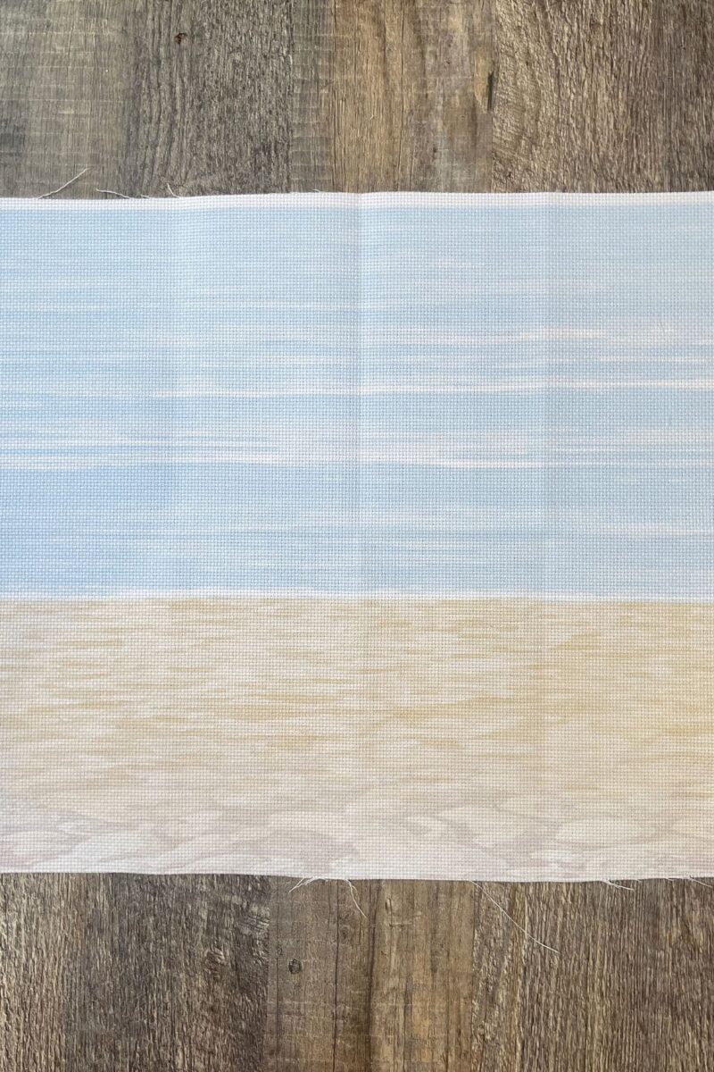 28 Count digitally printed cross stitch fabric with a beach scene with sand and sky