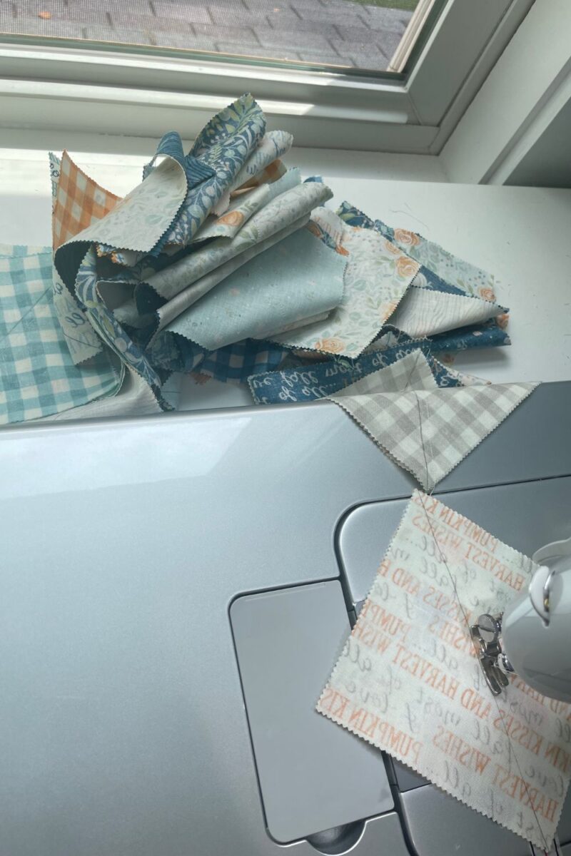 A Juki sewing machine demonstrating chain piecing quilt blocks without cutting the thread in between.