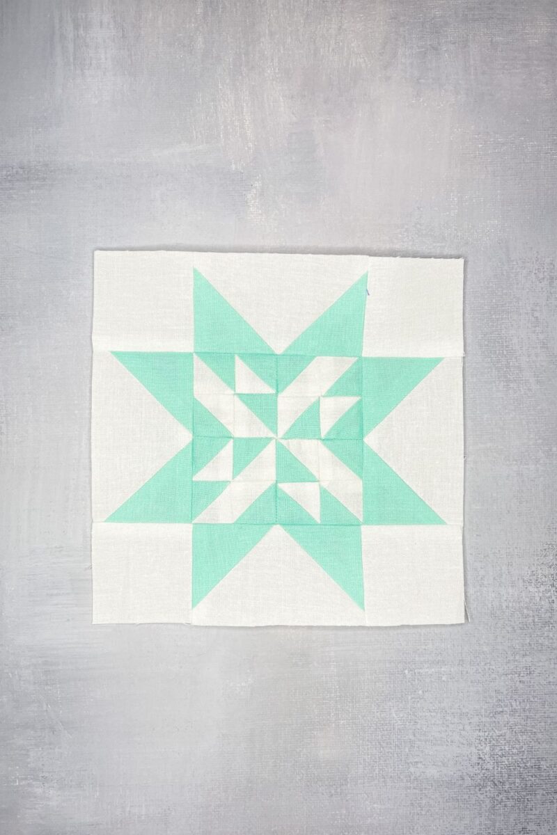 Twilight Stars block 90 in aqua and white. Features half square triangles for the center and flying geese frame.