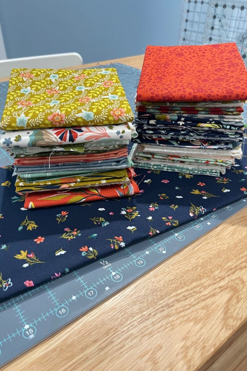 Songbook fat quarters on top of blue floral yardage from Songbook A New Chapter.