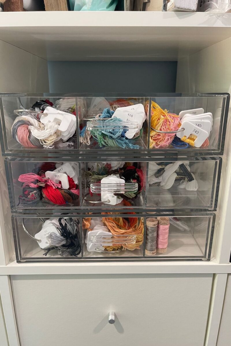 Multiple acrylic drawers with cross stitch floss sorted on binder rings and floss chips by Pip and Chip.