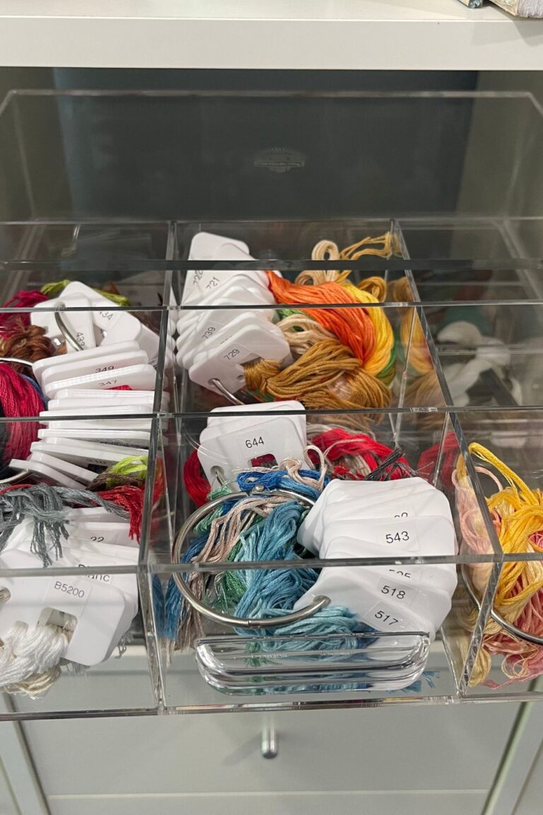 DMC cross stitch floss organized on floss drops in acrylic drawer organizers.