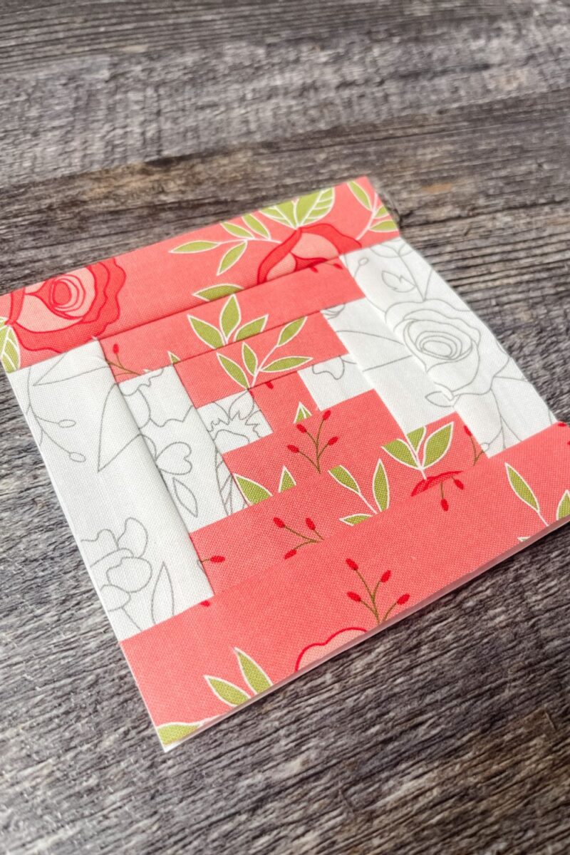 A courthouse steps quilt block made with 4 inch foundation paper in pink and white beautiful Day fabric.