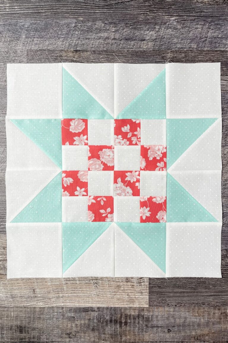 Adore Quilt block 7 uses the dark pink Lighthearted fabric arranged in a 16 patch with alternating white on white fabric. It has teal star points to complete the large block