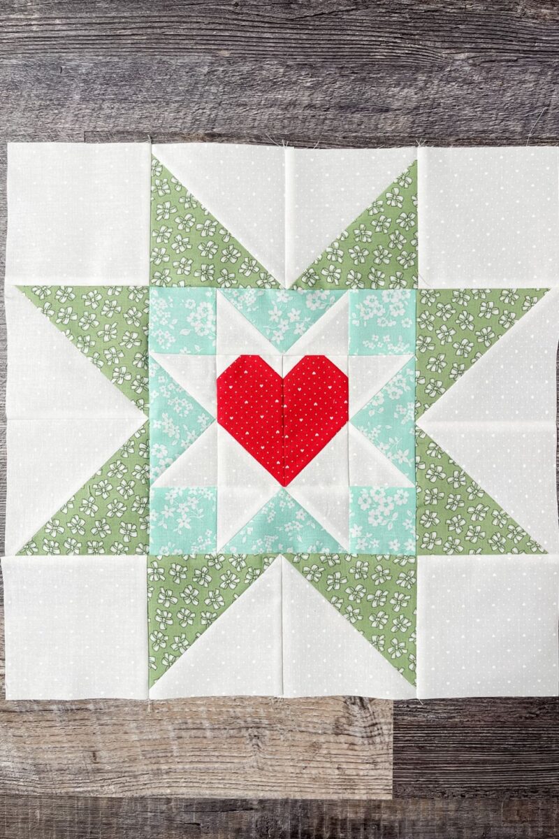 Moda Stitch Pink 2023 Block 5 is a heart block inside of a star block with larger star points.