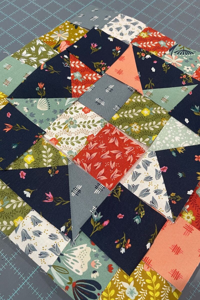 Layout of a scrappy quilt block. The block is the Super Scrappy Star block designed by Corey Yoder for Moda Blockheads 5 2023