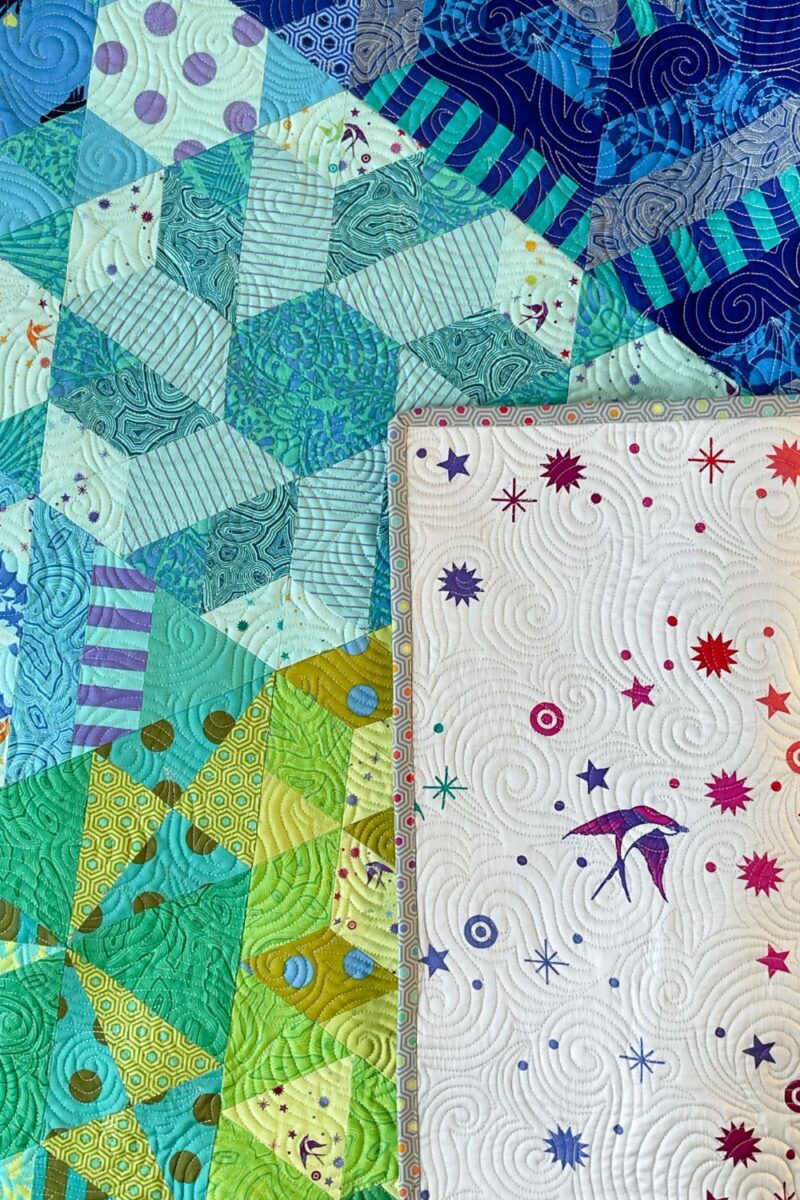 Close up of the Fairy Dust wide back fabric folded over the quilt blocks from the Nebula quilt pattern.