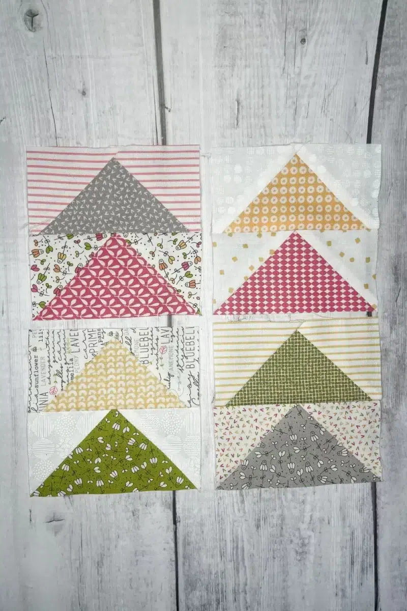 Flying geese blocks in a variety of colors, grey, pink, yellow, green, and multi colored background prints.