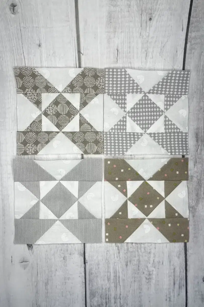 Grey and white quilt blocks made in a Mill Wheel design