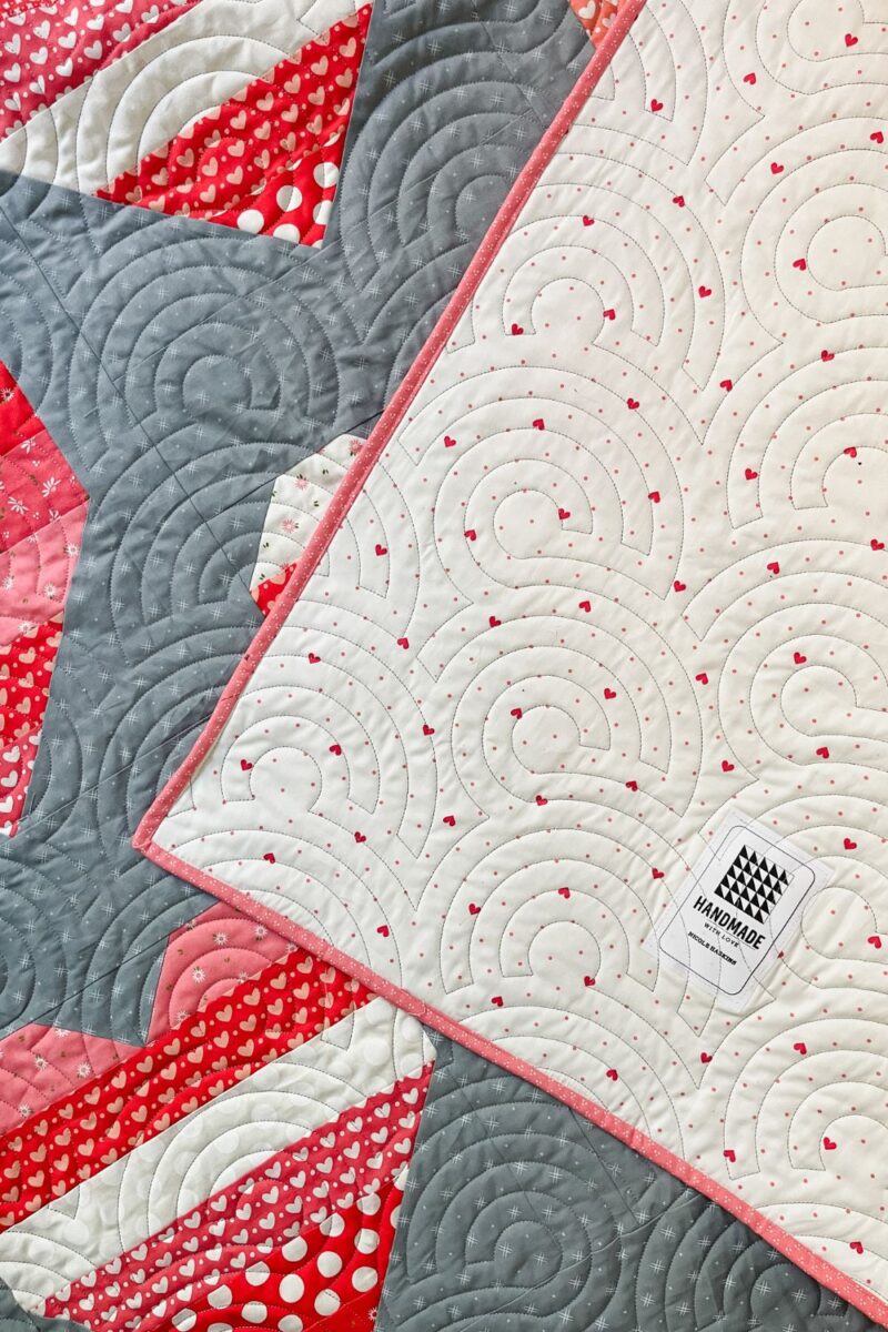 Quilt backing with heart print fabric from Lighthearted fabric collection. Quilted and has a label.