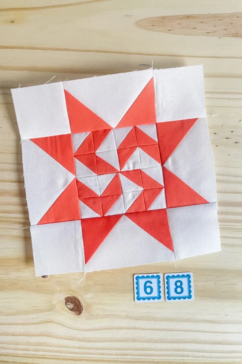 Star quilt block in orange and white. Made with 16 half square triangles in the center part of the star.