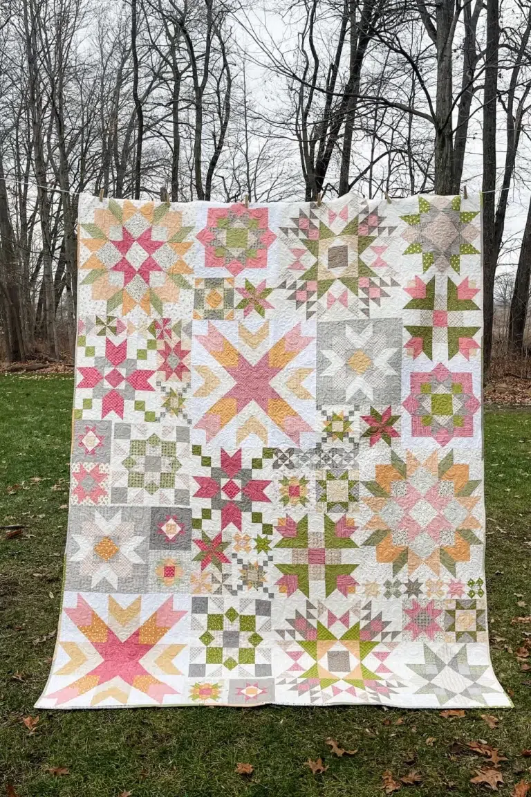 Completed barn star sampler quilt hanging on a line outside.