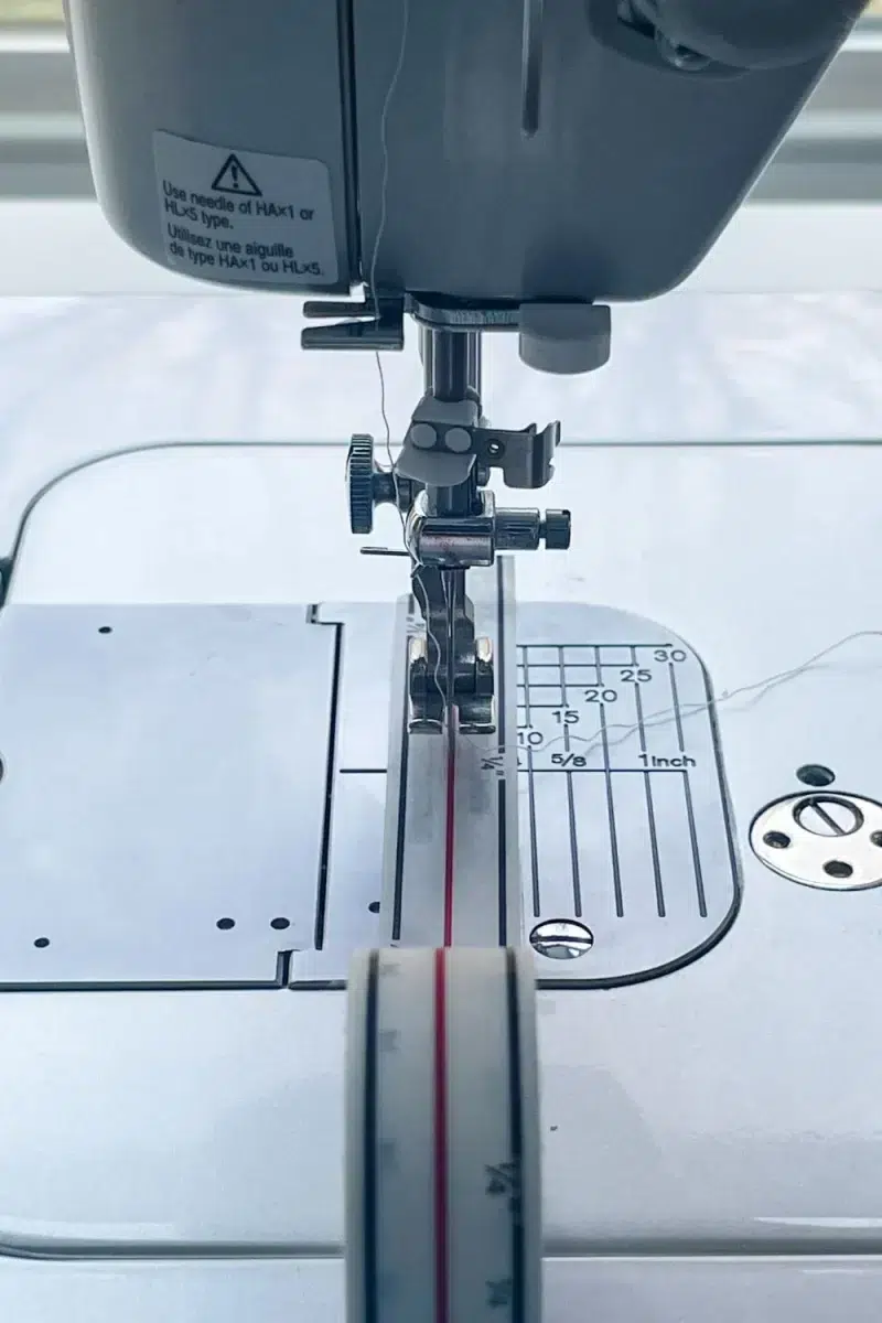 diagonal seam tape centered under a presser foot on a sewing machine
