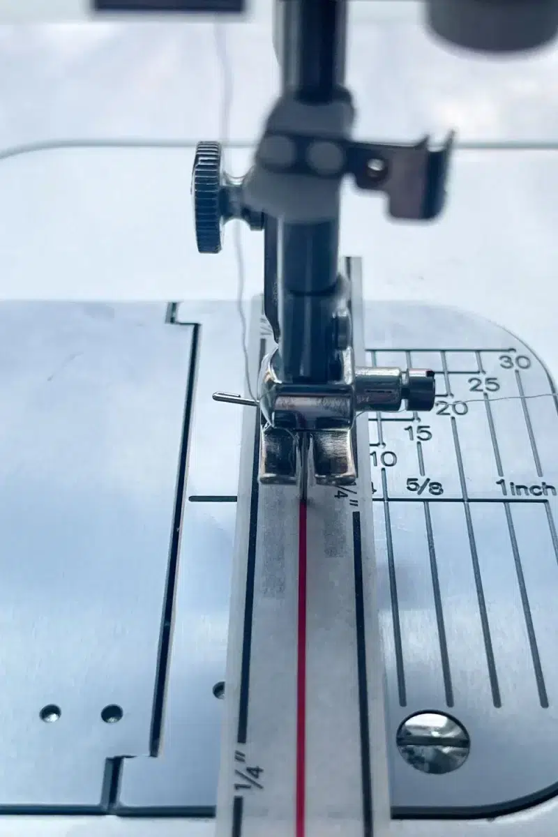 sewing machine needle through the center of diagonal seam tape on a sewing machine to line it up.