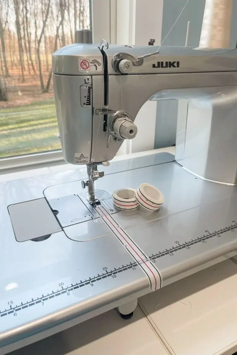 Sewing machine with diagonal seam tape applied to the machine bed and two rolls of the seam tape.