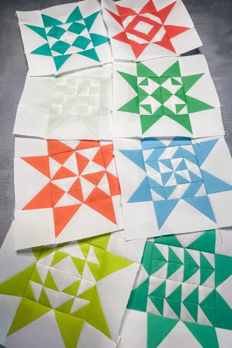 2 quilt blocks from the Triangle Gatherings Quilt Book. Made up of 16 half square triangles in the center and flying geese star points. This is the 8 multi-colored blocks from November.