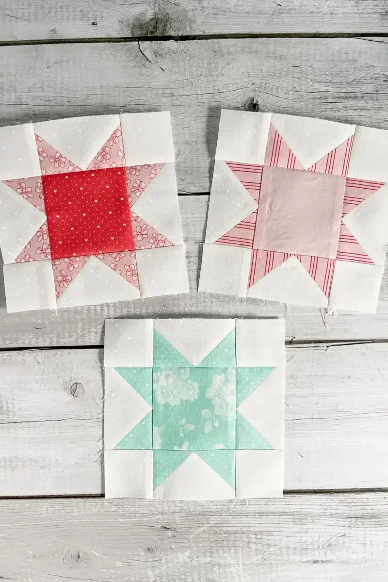 Three Eight Point Star quilt blocks made in pink, red, and teal