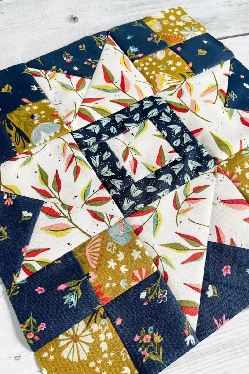 Quilt block for Moda Blockheads 5 Group 2 Block 3. A quilt block called the Shimmer Star. It is made with Songbook fabrics by Fancy That Design House.
