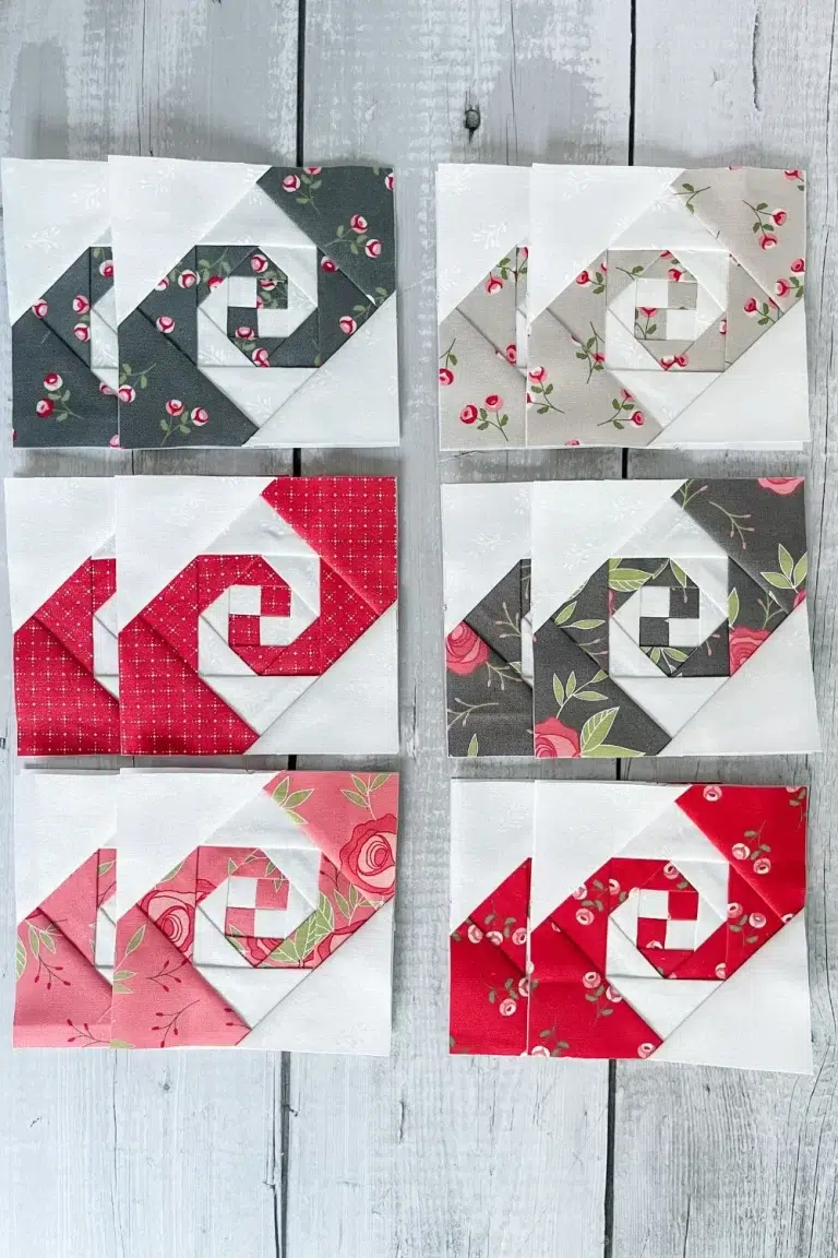 12 Snail Trail blocks in red, pink, grey, and taupe. Blocks made with foundation papers