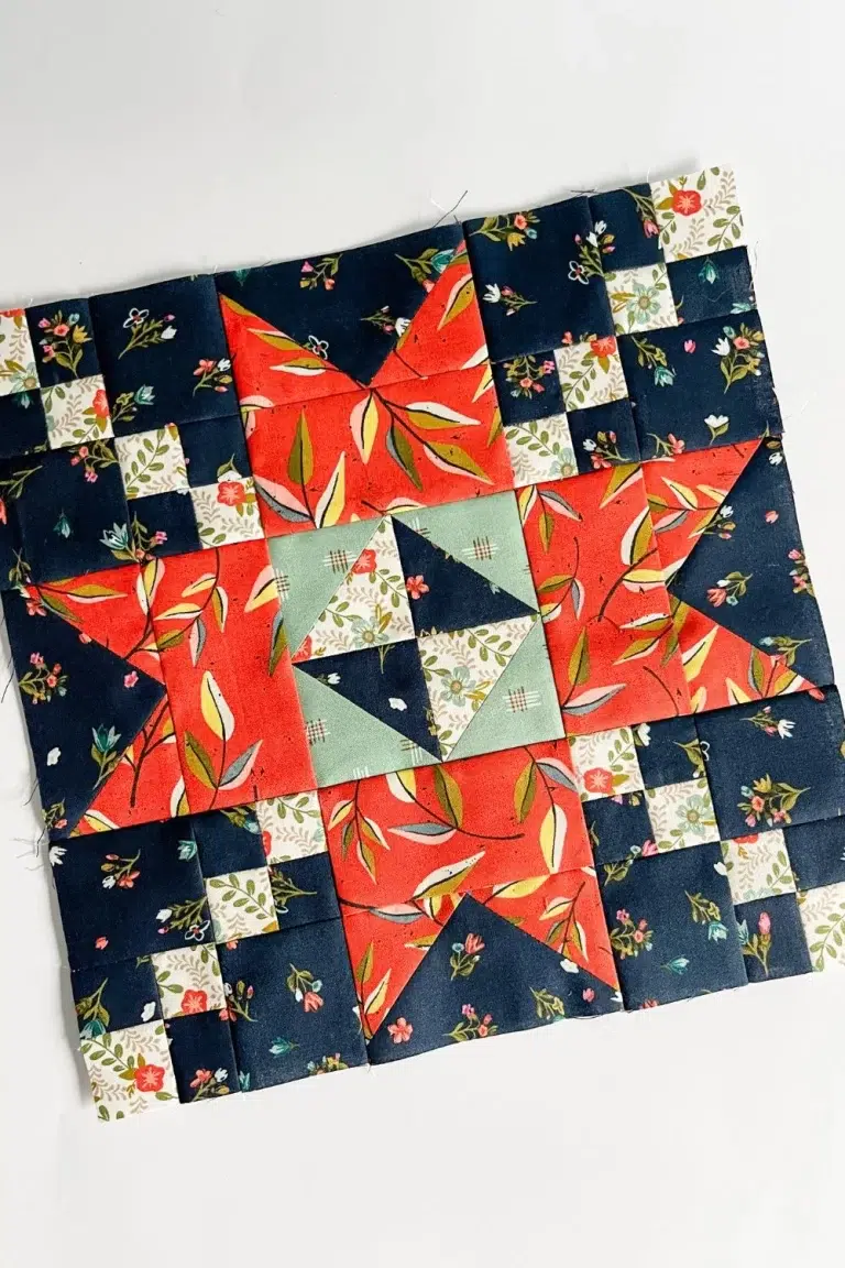 Sparkle quilt block in red, sage, navy, and white florals quilting fabrics.