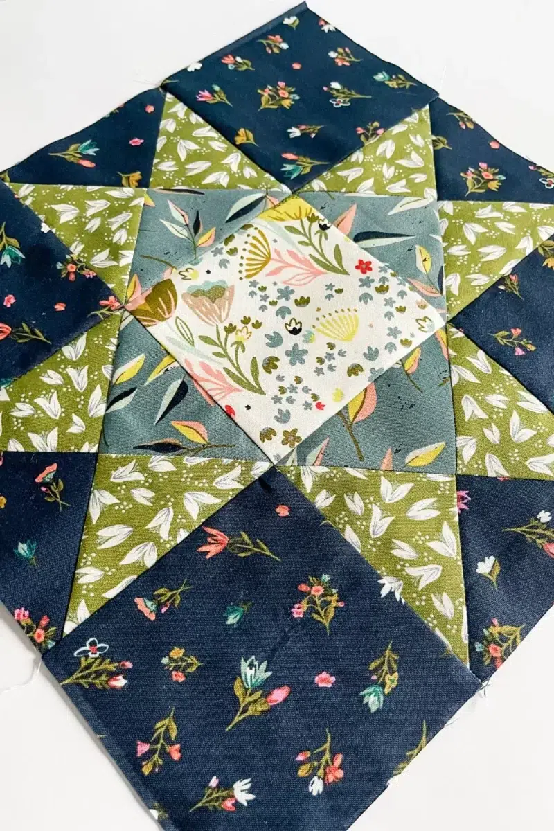 Ohio Star quilt block in green, navy, blue, and white floral prints
