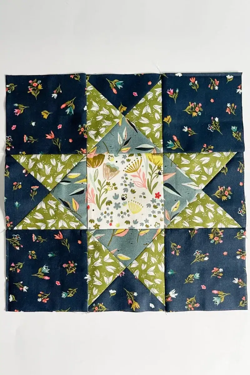 Ohio Star quilt block in green, navy, blue, and white floral prints