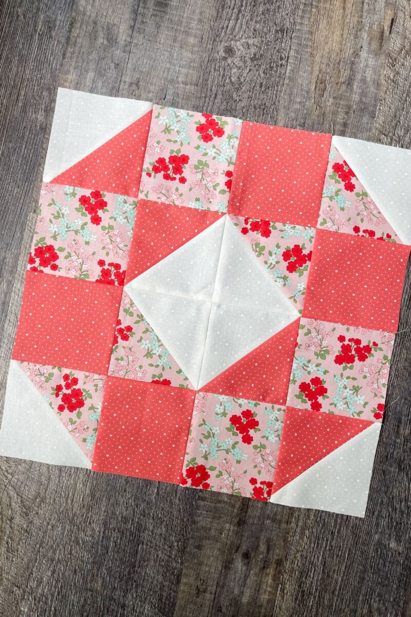 The Happy Day block is a circular pattern made with squares and half square triangle units using pink fabrics.