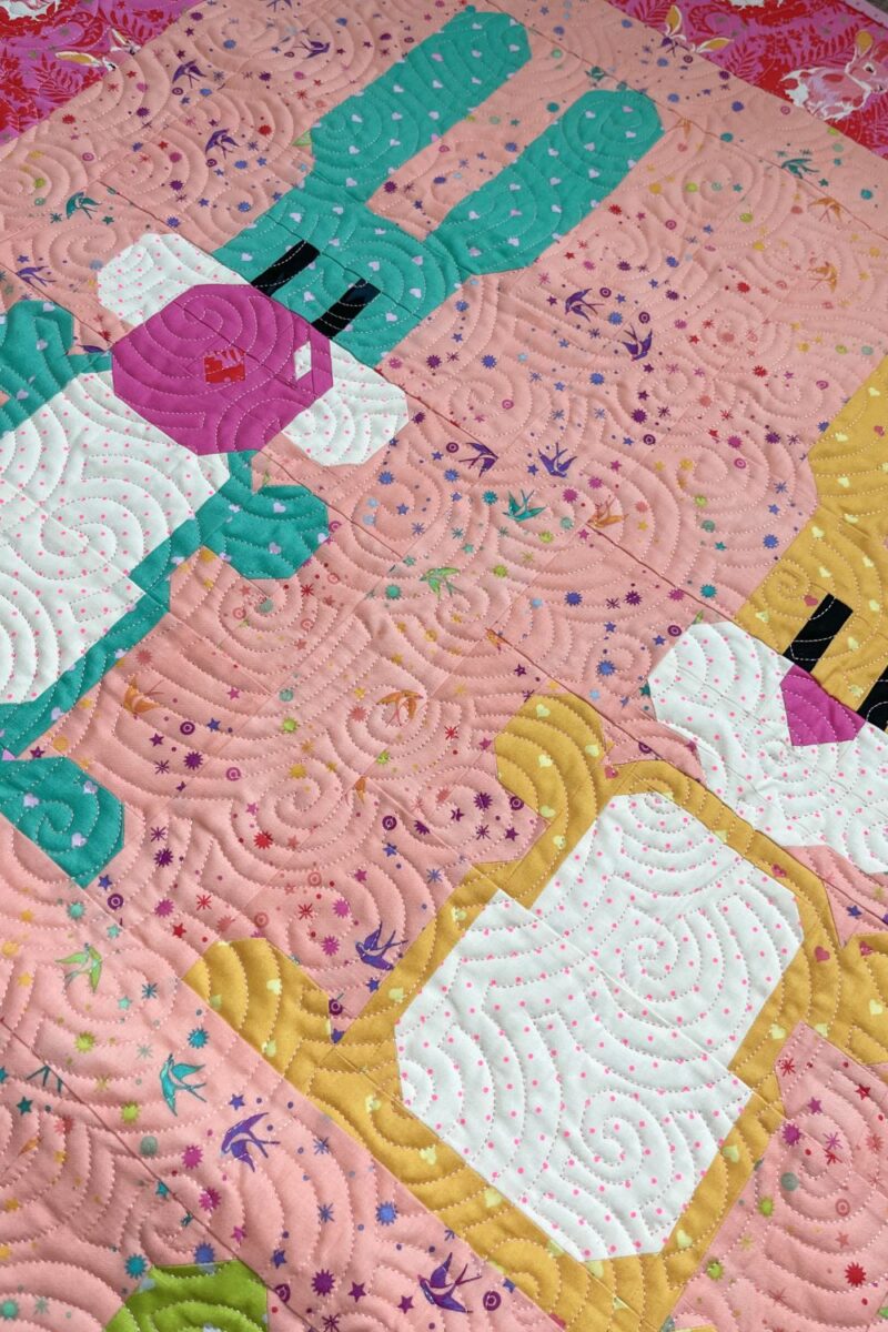 Angled view of the Blowing Up Bunnies quilt to show the finished quilting pattern.