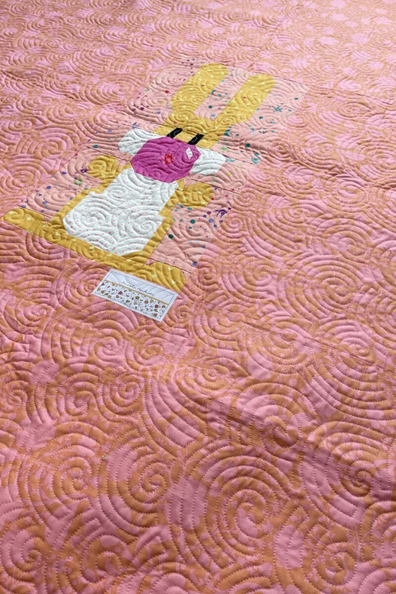 Backing of the quilt using one extra quilt block and a quilt label in the middle.