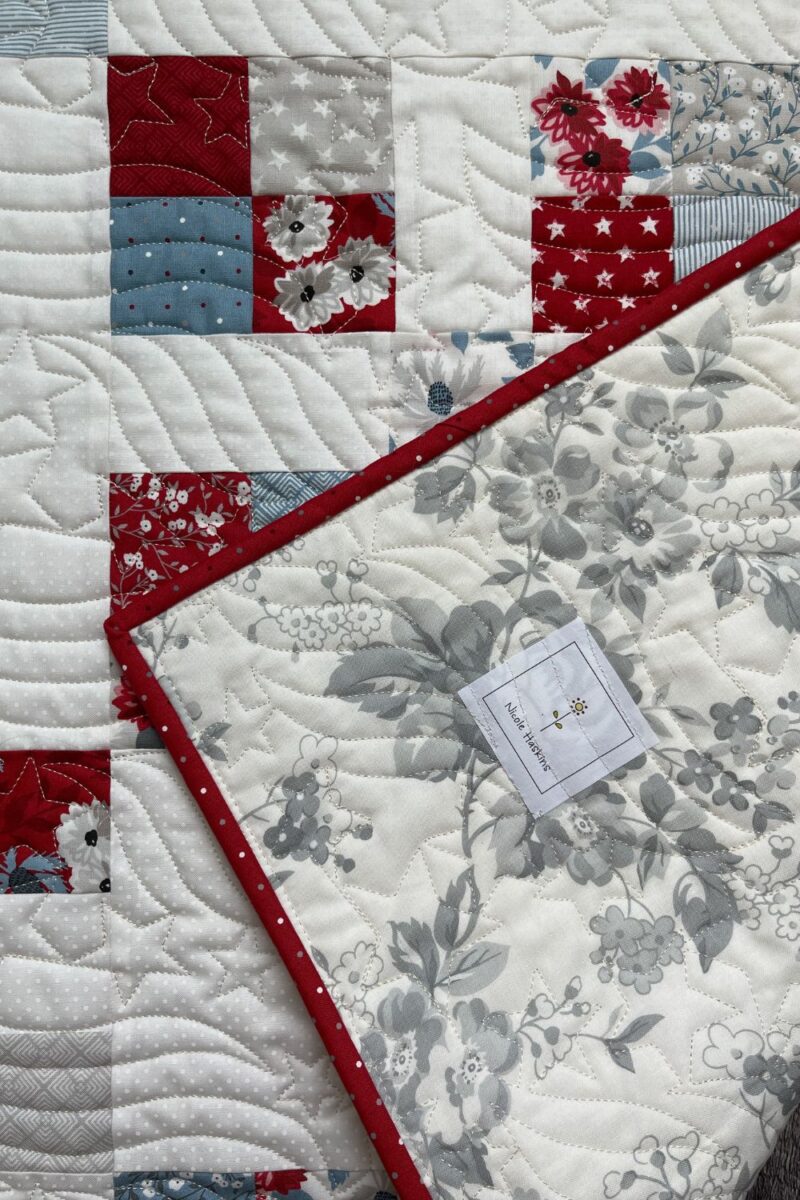 The quilt back of the mini charm quilt for month 2 of Moda mini charm club. Also uses a custom quilt label.