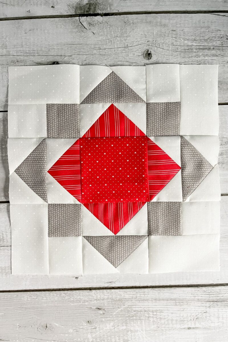 Red, grey, and white quilt block with flying geese and squares making the Sunshine Quilt Block
