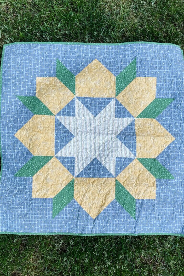 Swoon baby quilt features a single large star in the center of the quilt.