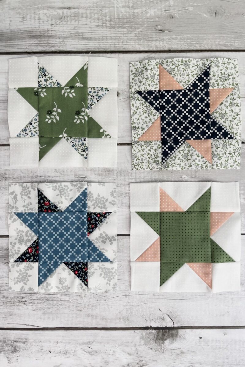 Four 8 point star quilt blocks made in a variety of green, pink, blue, and white fabrics.