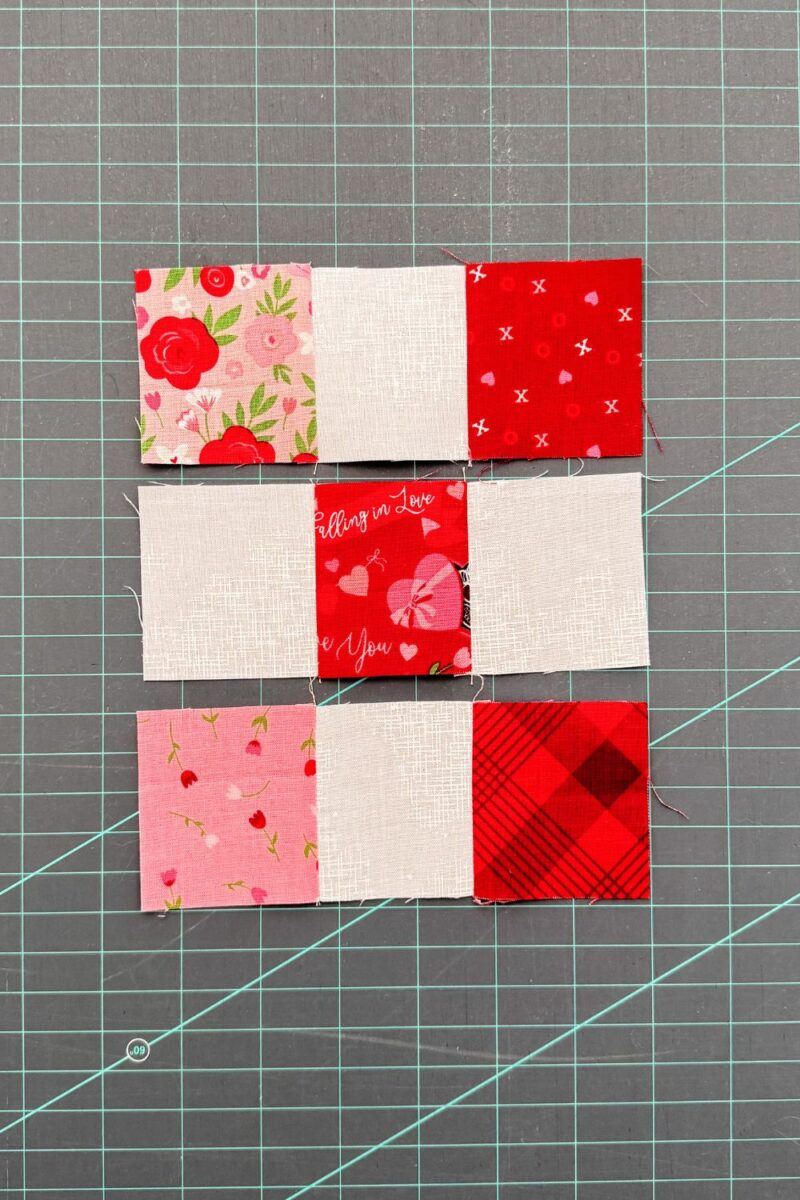 Pressing each of the rows for a traditional nine patch quilt block towards the dark fabrics