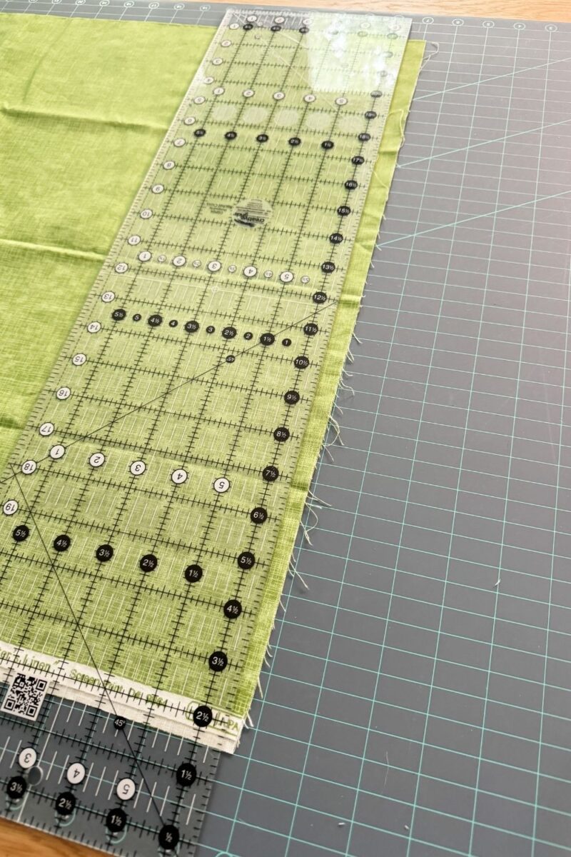Squaring up quilt fabric by aligning the selvage edges before cutting.