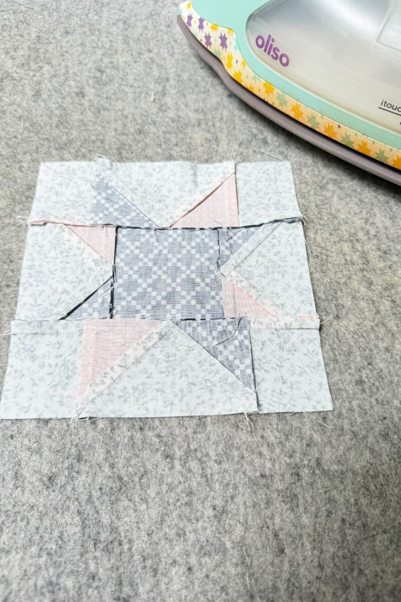 Pressing seams to the side on the back of a quilt block