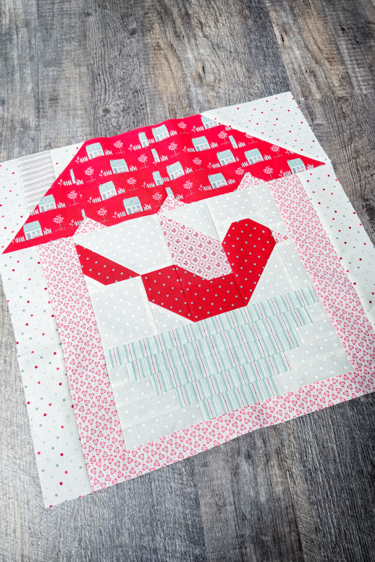 Feather Your Nest quilt block in the finished block setting of a house frame around the completed block.