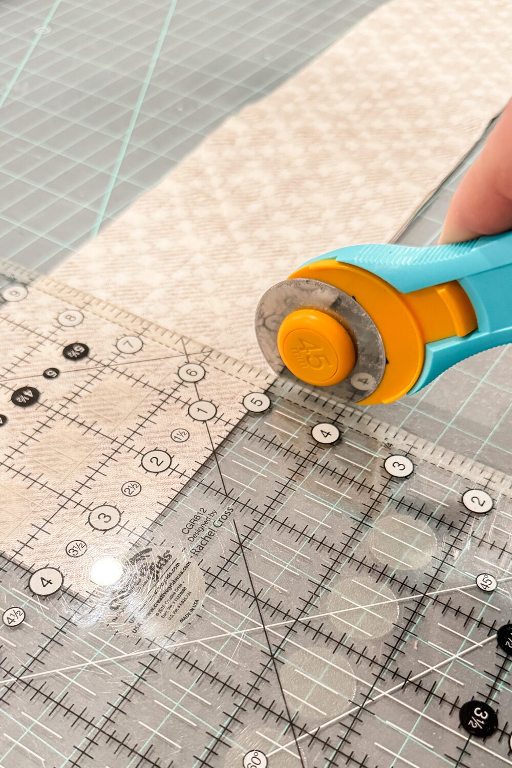 Properly using a rotary cutter perpendicular to the fabric on the edge of a quilting ruler