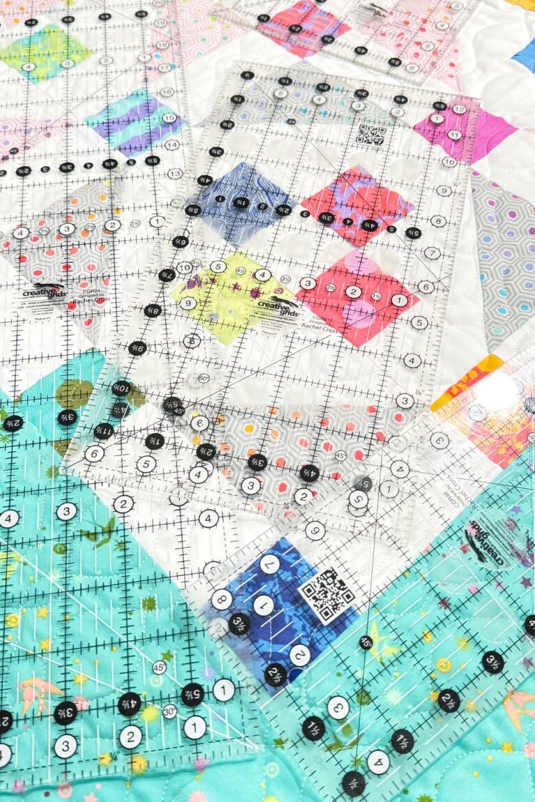Collection of beginner quilting rulers, featuring a 6x24-inch ruler and a square ruler on a quilt