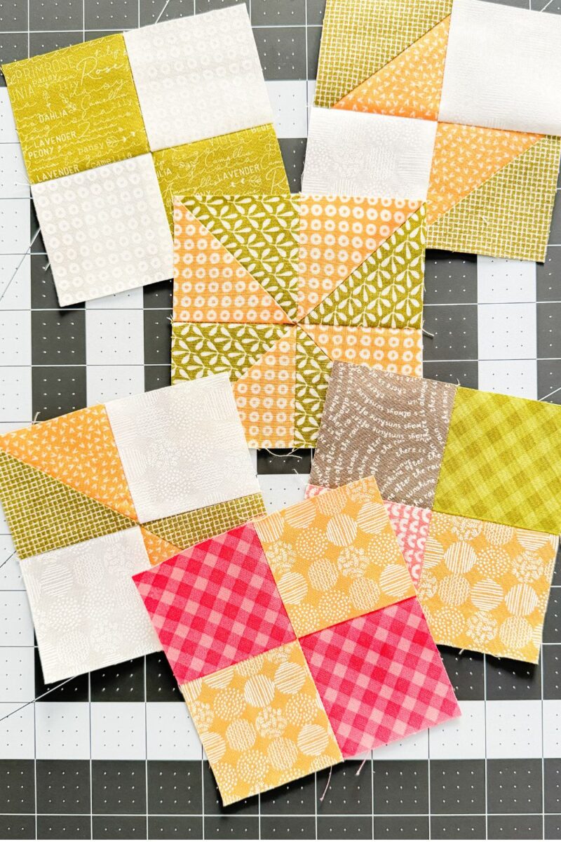 Six different variations of a four patch quilt block arranged on a cutting mat. Some are basic four patches, some use half square triangles to give variety.