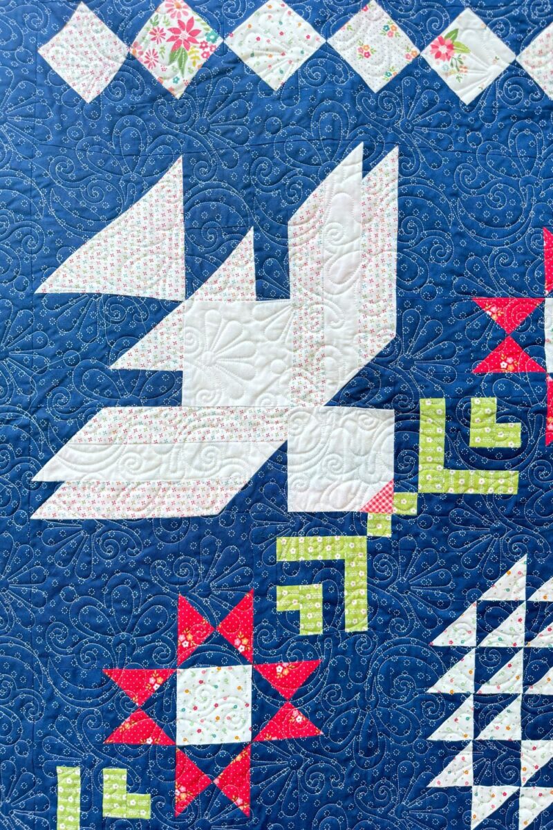 Close up of the Dove quilt block in the finished Moonbeams quilt from the charity quilt along hosted by Fat Quarter Shop.