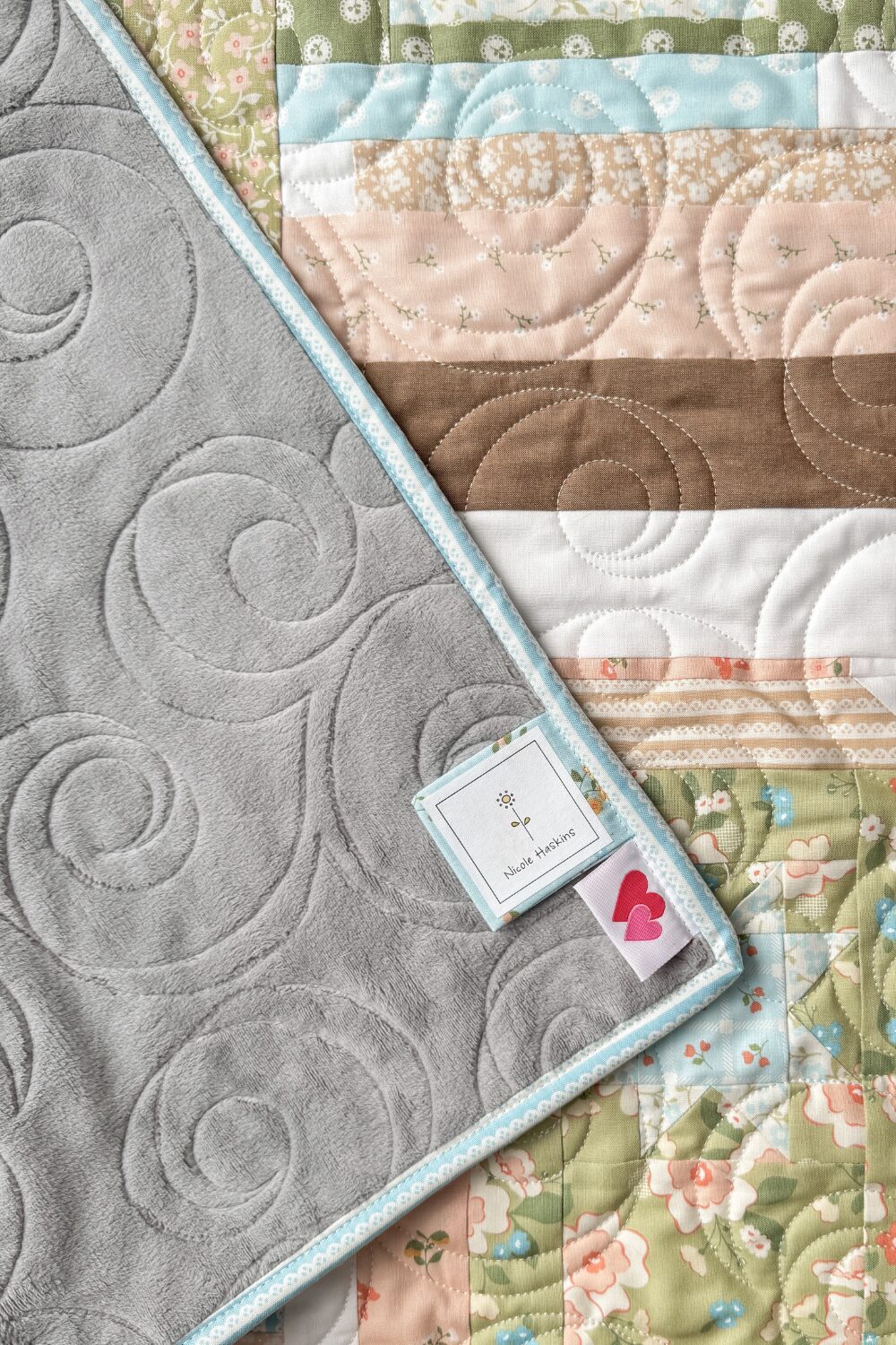 A close-up of the grey Shannon Cuddle fabric backing on a quilt.