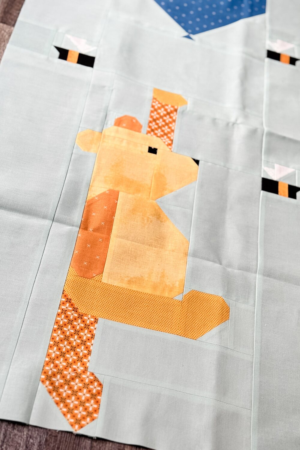 Close-up of Winnie the Pooh in the quilt block, pieced with yellow fabric.