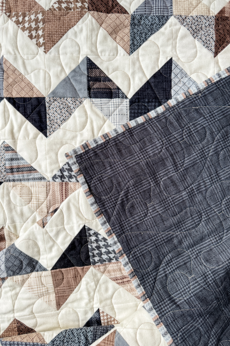 Zig Zag Quilt with a flipped corner, showing the front zig-zag design and black plaid flannel backing.