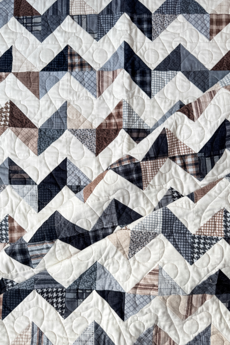 Close-up of the folded Zig Zag Quilt, showing soft flannel textures and precise stitching details.