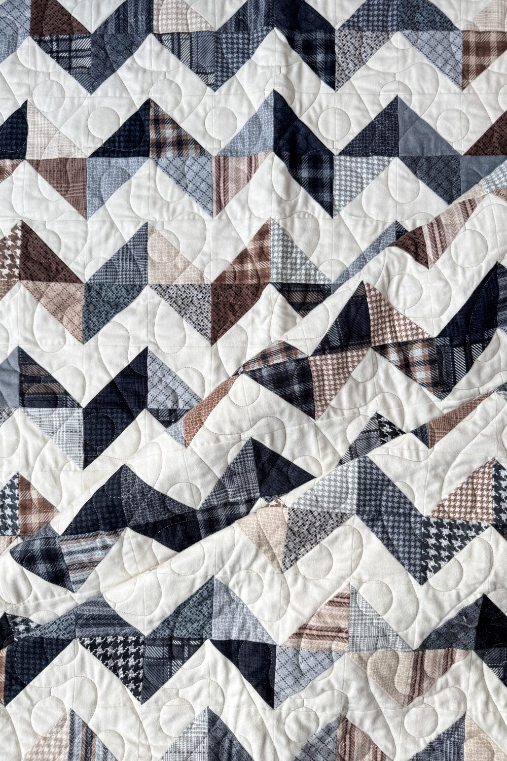 Close-up of the folded Zig Zag Quilt, showing soft flannel textures and precise stitching details.