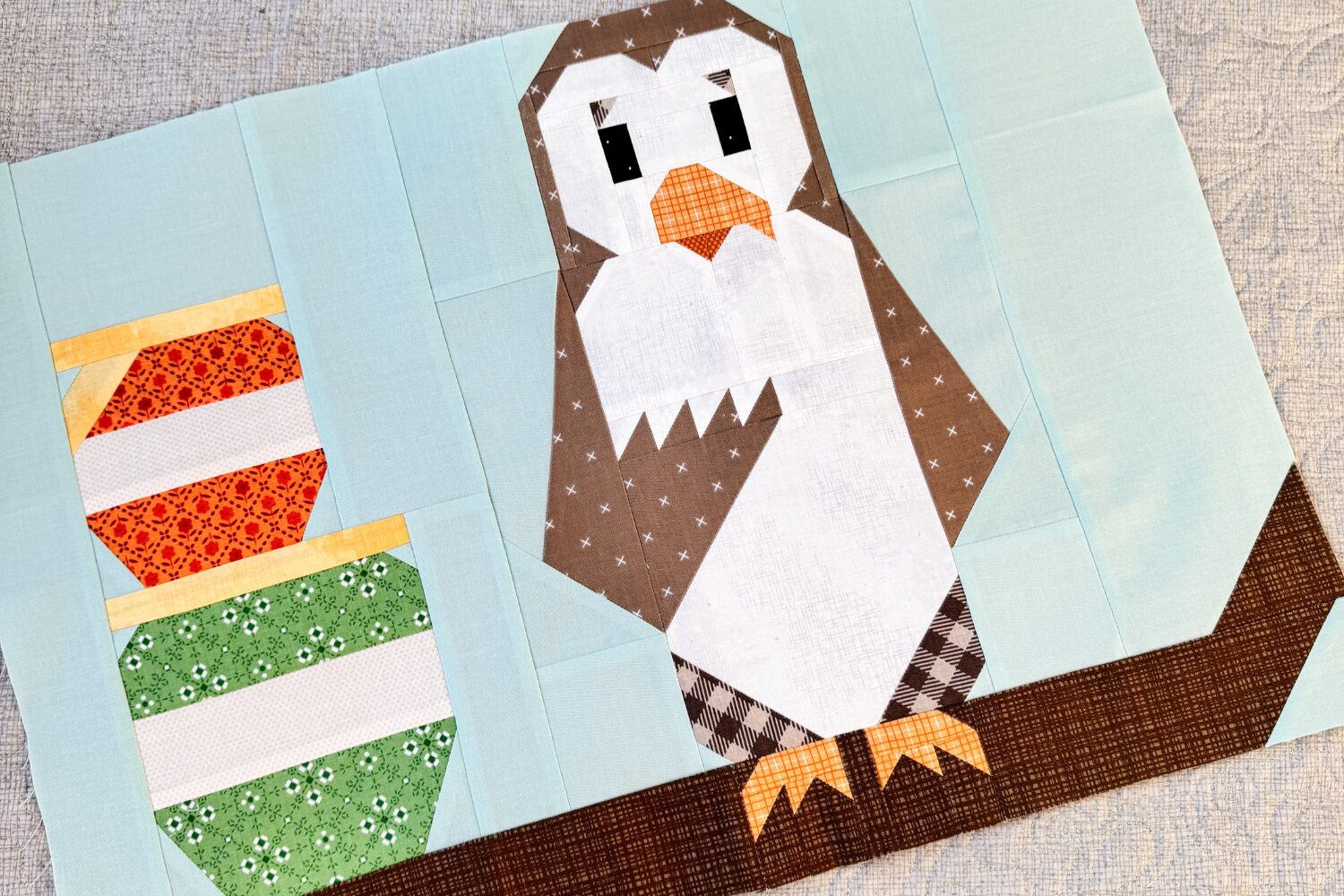 Finished Owl quilt block with Owl on a branch next to stacked hunny pots, sewn with Riley Blake fabrics.