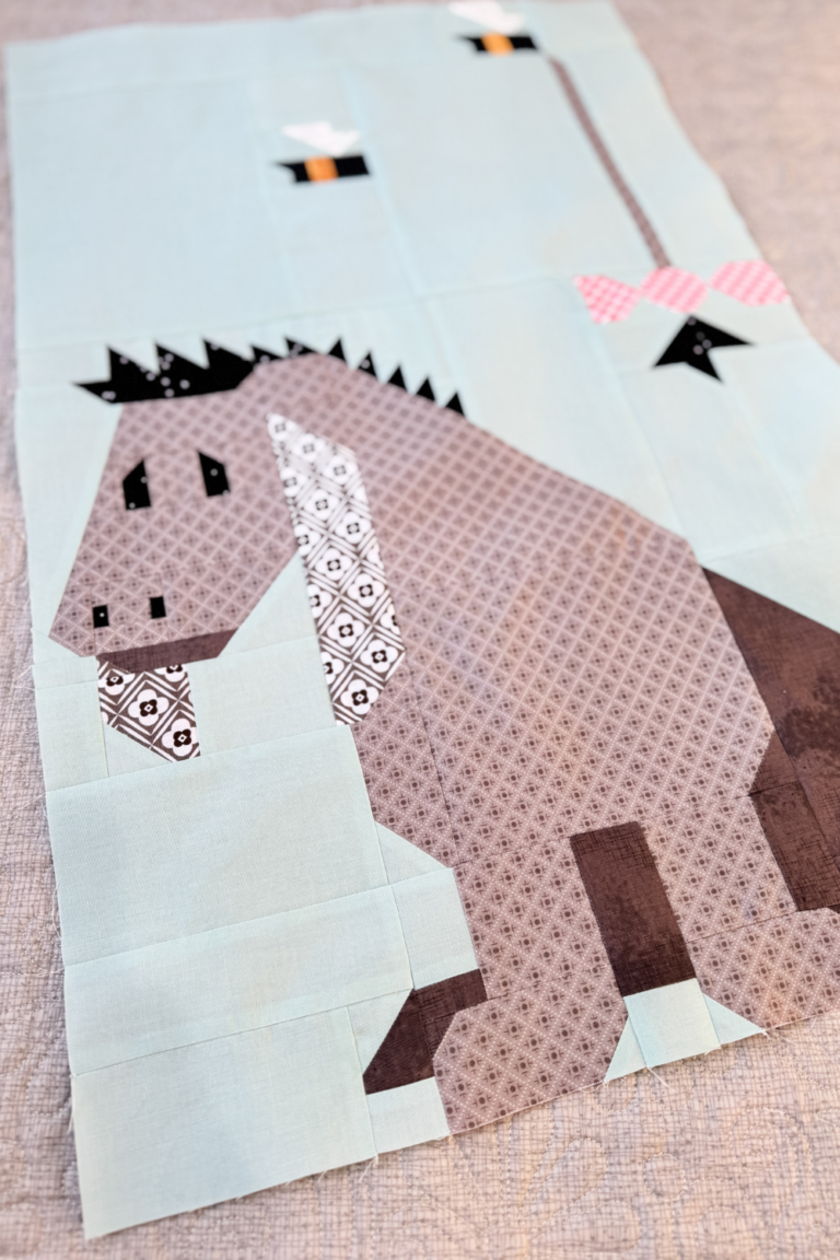 Close-up of Eeyore quilt block highlighting Eeyore’s face and tail in the sky.