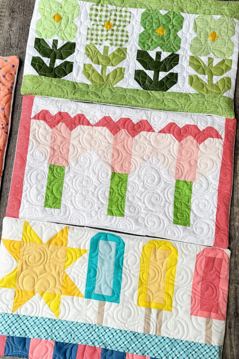 Three quilted bench pillows made from scraps of seasonal door banner kits with envelope-style backs.